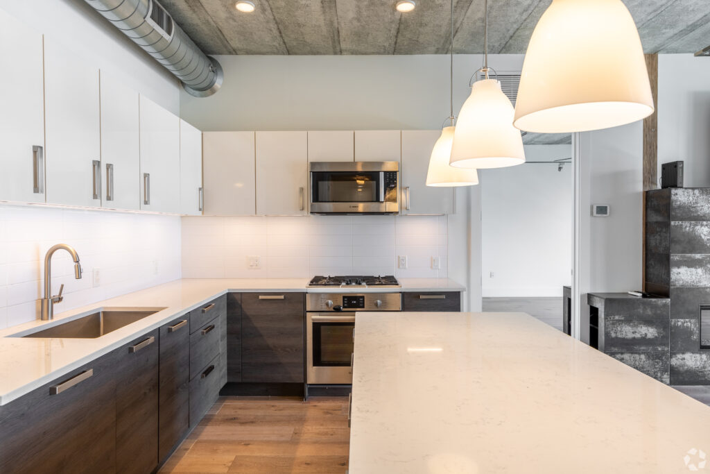 large white kitchen island with three lamps hanging over it