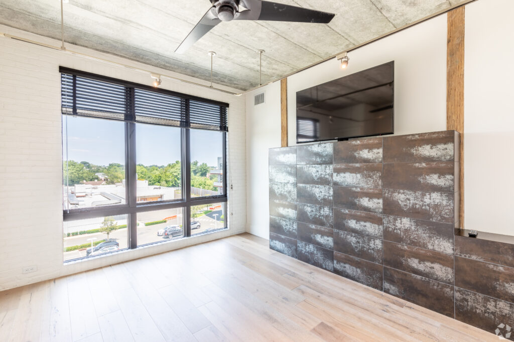 large master bedroom with a decorative wood entertainment unit and television